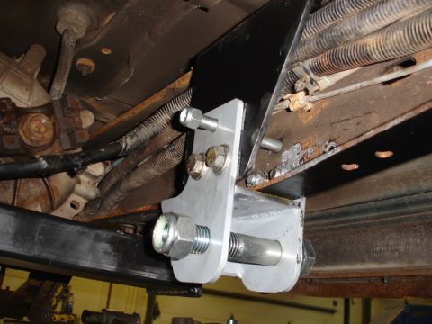1996 Ford Bronco - Close-up view of aftermarket chassis modifications, showing bolted metal brackets and suspension parts.