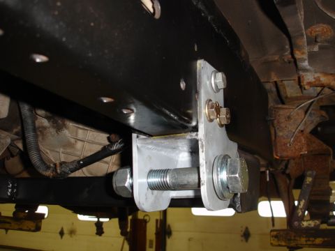 1996 Ford Bronco - Close-up view of a custom suspension bracket modification on a vehicle's frame.