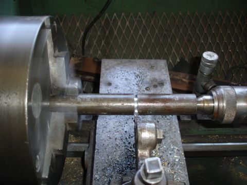 1996 Ford Bronco - Machining a metal rod on a lathe, with metal shavings visible.