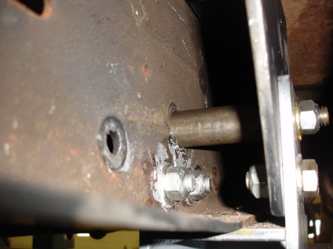 1996 Ford Bronco - Detail of a metal frame assembly with fasteners and a cylindrical rod.