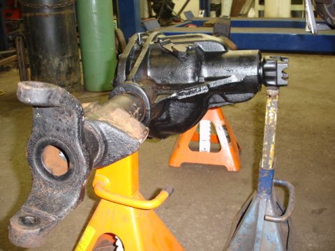 1996 Ford Bronco - A front axle differential assembly is shown supported by jack stands in a workshop setting.
