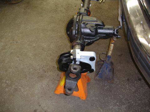 1996 Ford Bronco - A vehicle's axle assembly is supported by jack stands in a garage setting.