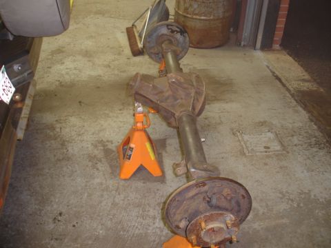 1996 Ford Bronco - A rear axle assembly is supported by orange jack stands in a garage setting.
