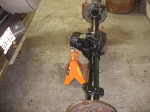 1996 Ford Bronco - A rear axle assembly, likely from a truck or SUV, is supported by jack stands in a garage setting.