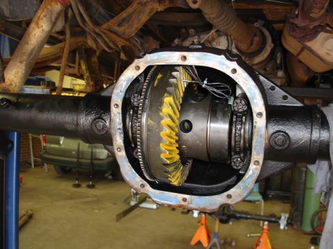 1996 Ford Bronco - The differential housing is open, revealing the internal gears. The vehicle is elevated on jack stands for maintenance.