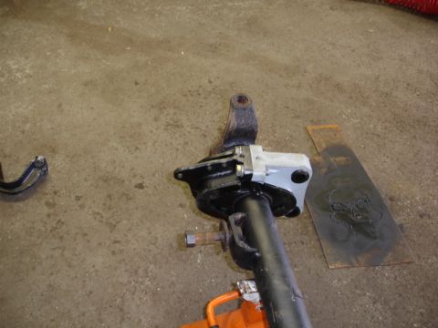 1996 Ford Bronco - A disassembled vehicle suspension component rests on a workshop floor.