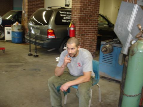 1996 Ford Bronco - Garage scene with a man seated and two vehicles in the background.