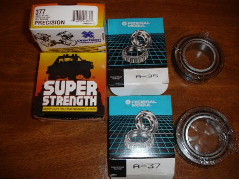 1996 Ford Bronco - Several automotive parts, including universal joints and wheel bearings, are laid out on a wooden surface.