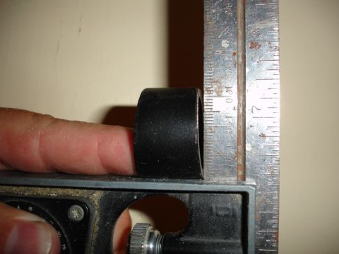 1996 Ford Bronco - A finger holds a black cylindrical object next to a ruler for measurement.