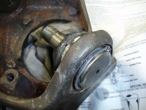 1996 Ford Bronco - Close-up of a worn ball joint assembly with a diagram visible in the background.