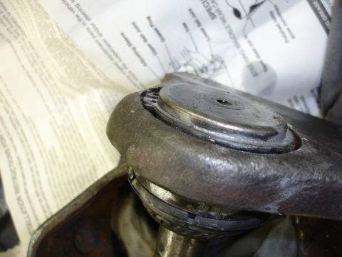 1996 Ford Bronco - Close-up of a ball joint assembly, with a diagram visible in the background detailing its components.