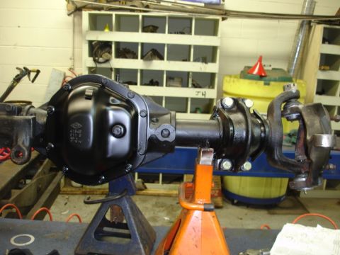 1996 Ford Bronco - A close-up view of a differential axle assembly, likely undergoing maintenance or restoration in a garage setting.