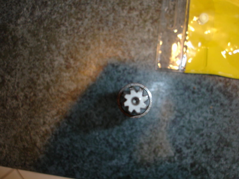 Close-up of a white gear with 10 teeth inside a metal ring