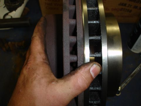 1996 Ford Bronco - Close-up of a hand holding a vented brake rotor, indicating a mechanical part.
