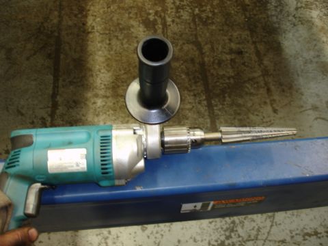 1996 Ford Bronco - A teal power drill is shown with a reamer bit and a side handle, resting on a blue surface.