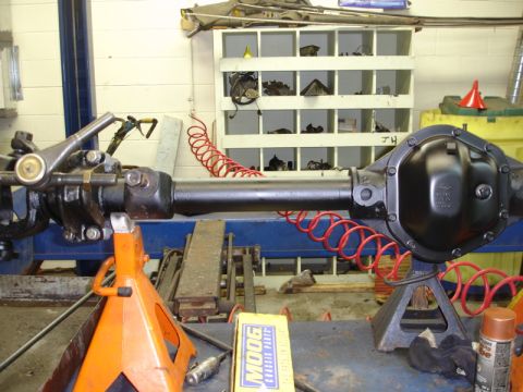 1996 Ford Bronco - A rear axle assembly is supported by jack stands in a workshop environment.