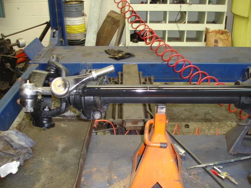 close-up of vehicle steering linkage and suspension parts on a lift