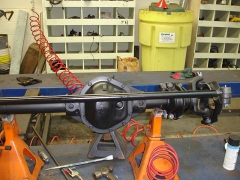 1996 Ford Bronco - A differential axle assembly is shown on jack stands in a workshop setting.