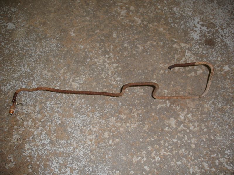 Rusted metal brake line on concrete floor