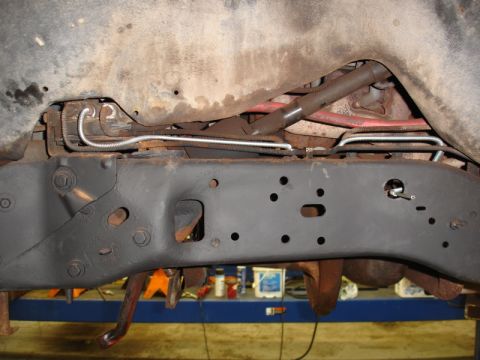 1996 Ford Bronco - Undercarriage view of a vehicle frame, showing brake lines and suspension parts.