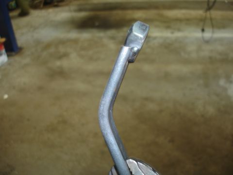 1996 Ford Bronco - A close-up view of a vehicle's brake pedal assembly, showing the metal arm and textured pad.