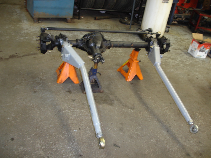 Front axle assembly with suspension components on orange and blue jack stands