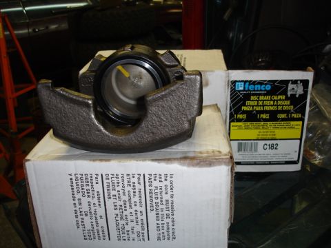 1996 Ford Bronco - A new disc brake caliper sits on top of its packaging, ready for installation.