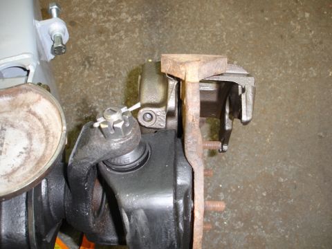 1996 Ford Bronco - A close-up view of the brake caliper and suspension parts of a vehicle.