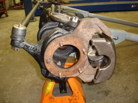 1996 Ford Bronco - A vehicle's suspension knuckle assembly, likely from the front end, is shown supported by an orange jack stand.