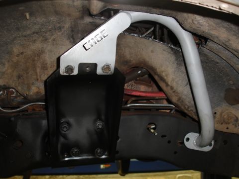 1996 Ford Bronco - Close-up view of a custom roll cage bracket installed on a vehicle's undercarriage.