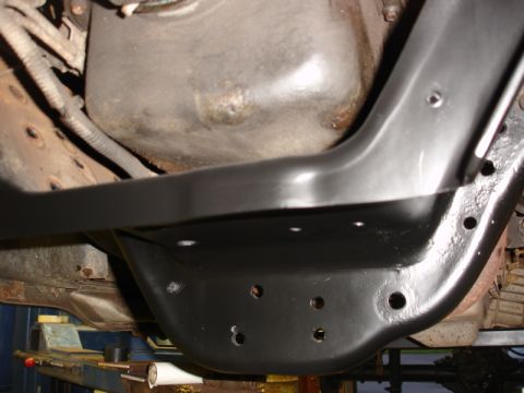 1996 Ford Bronco - Undercarriage view of a vehicle's frame, showing newly painted black metalwork and engine components.