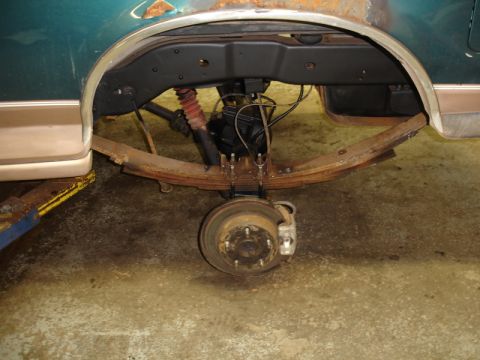 1996 Ford Bronco - The rear suspension and wheel assembly of a vehicle shows significant rust and wear.
