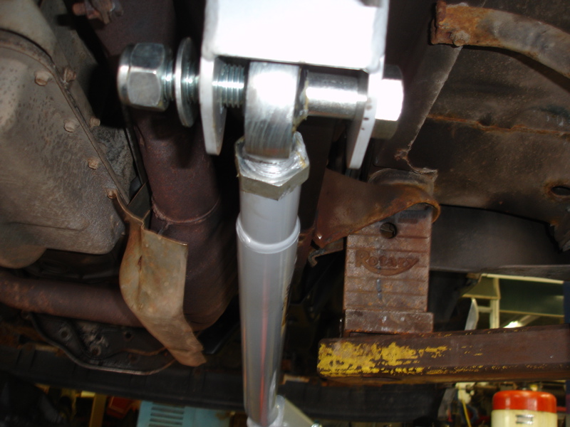 Close-up of rusty underbody suspension parts and exhaust pipe