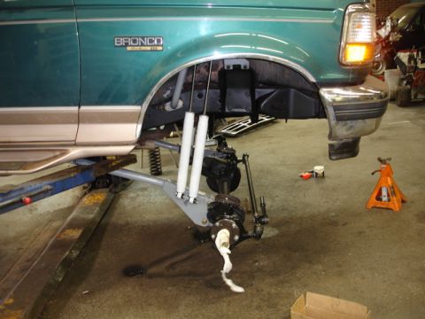 1996 Ford Bronco - The front suspension of a 1996 Ford Bronco is undergoing maintenance, with parts removed for repair.