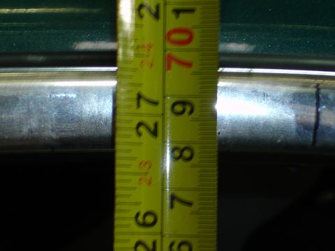 1996 Ford Bronco - A yellow measuring tape is used to measure a chrome bar, with markings up to 27 inches visible.