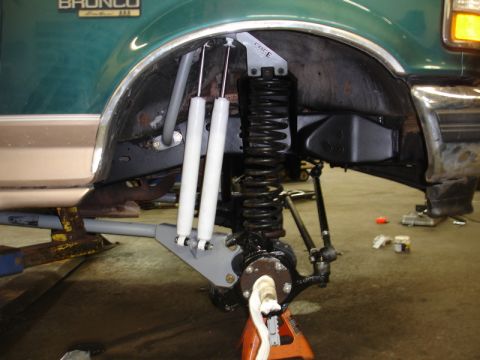 1996 Ford Bronco - Close-up of the front suspension of a 1996 Ford Bronco undergoing modifications.