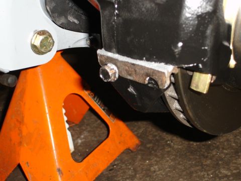 1996 Ford Bronco - Close-up view of a vehicle's brake assembly, showing the rotor and caliper, supported by an orange jack stand.