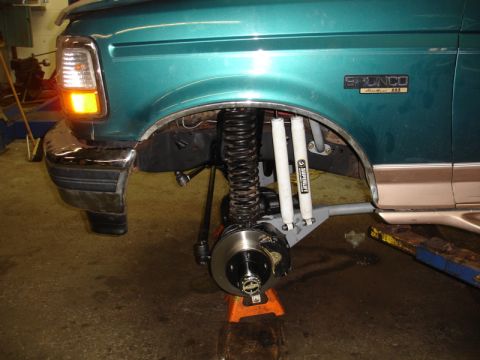 1996 Ford Bronco - Front suspension and fender of a 1996 Ford Bronco undergoing work, showing new shocks.