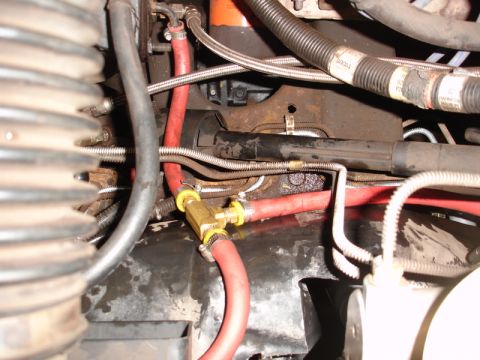1996 Ford Bronco - Close-up view of engine bay components, including red hoses and a brass T-fitting.