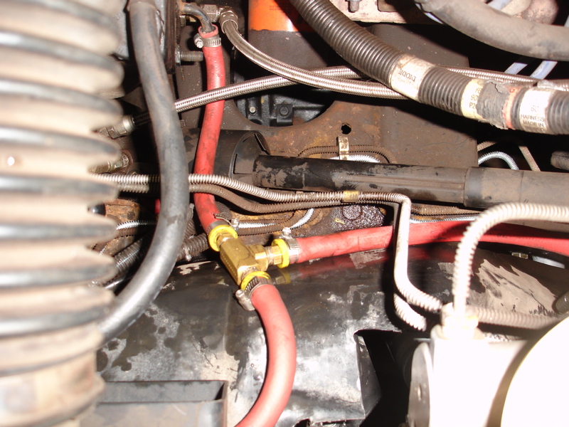 Engine bay detail with red hoses and brass T-fitting