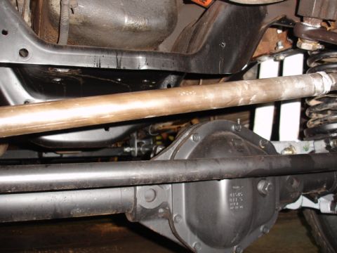 1996 Ford Bronco - Close-up view of the rear differential and suspension system of a vehicle, showing various mechanical parts.