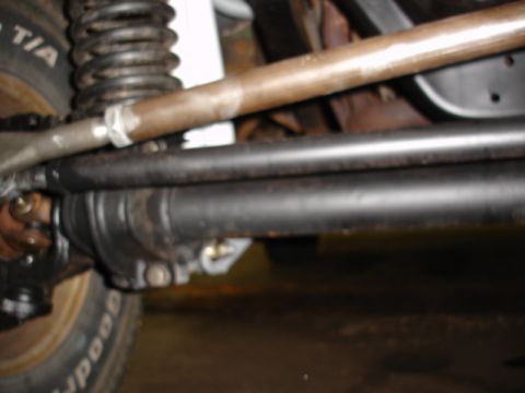 1996 Ford Bronco - Undercarriage view shows the steering and suspension system of a vehicle, including the front axle and a coil spring.
