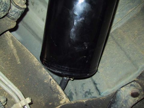1995 Ford Bronco - Underside view of a vehicle's fuel filter, showing its connection and mounting.