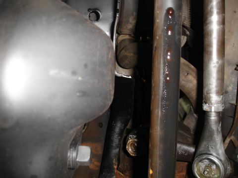 1996 Ford Bronco - Detail view of vehicle steering components, showing metal rods and connections.