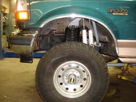 1996 Ford Bronco - The front suspension and wheel well of a 1996 Ford Bronco are visible, showing modifications for a lift.