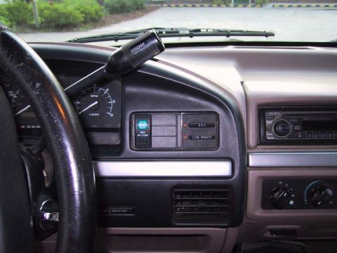 1995 Ford Bronco - Interior shot of a truck's dashboard, the steering wheel, gear shifter, and radio controls.