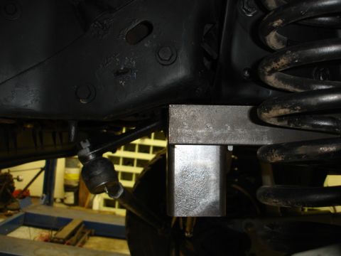 1996 Ford Bronco - A close-up view of a vehicle's suspension system, showing a metal spacer and a coil spring.