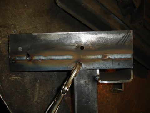 1996 Ford Bronco - A metal plate shows evidence of welding and is held by a clamp.