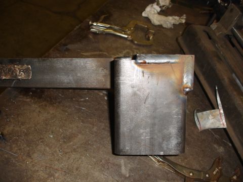 1996 Ford Bronco - A metal bracket is shown after being welded, with clamps securing it to a work surface.