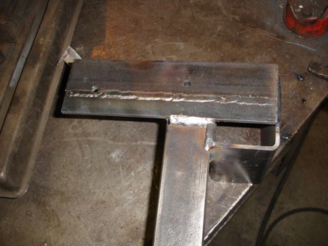 1996 Ford Bronco - A close-up view of a custom-fabricated metal part, showing welds and drilled holes.